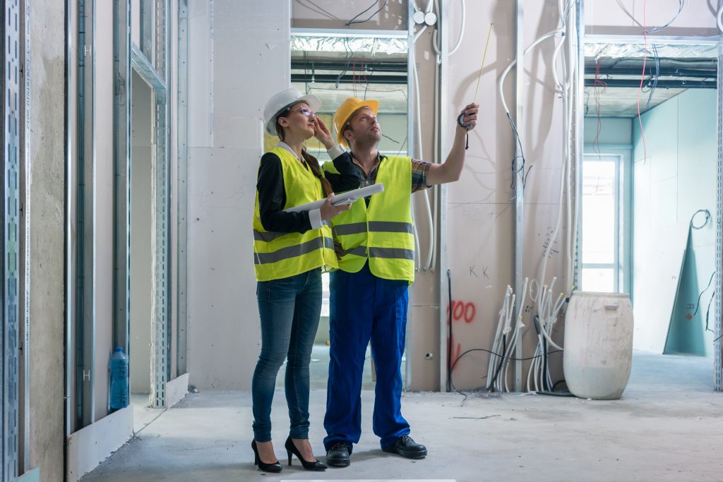 construction worker and architect discussing work to be done at site construction worker and architect discussing work to be done at site